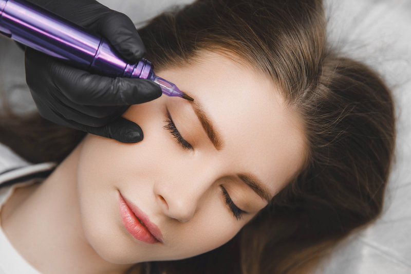 A cosmetologist applies permanent makeup to the eyebrows during permanent makeup near Palm Beach